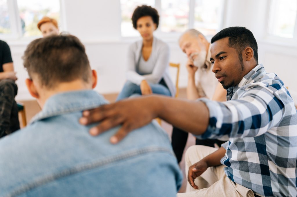 A grief mentor offering support in a peer counseling circle.